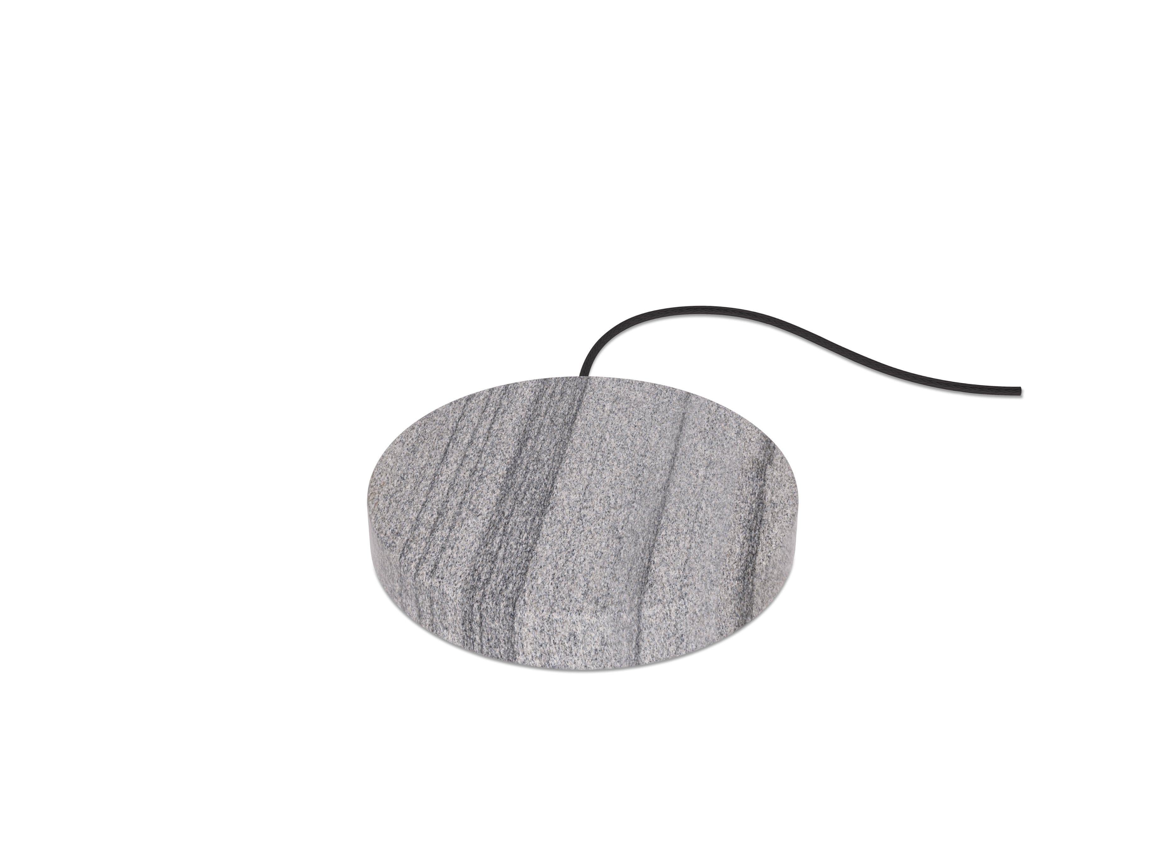 Einova Charging Stone on a modern desk with smartphone charging